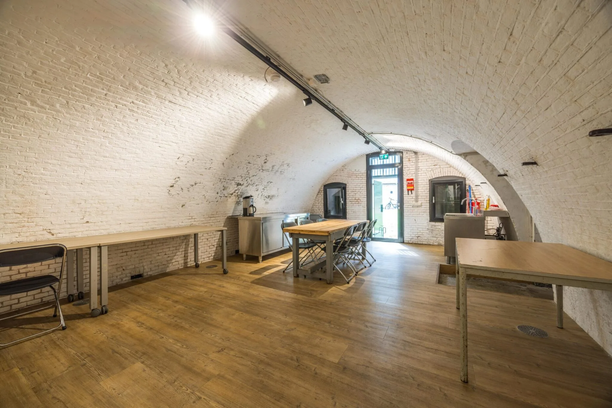 Ruimte met gewelfde bakstenen plafonds aan de Vossegatsedijk, ingericht als vergaderruimte met houten tafels en stoelen.