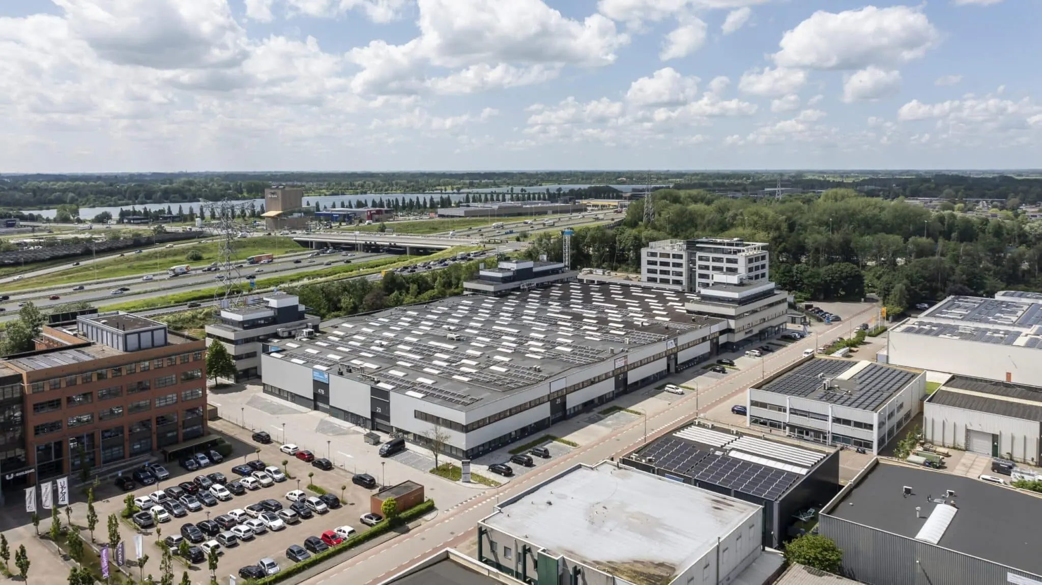 Luchtfoto van bedrijvenpark Zonnebaan in Utrecht met kantoren, magazijnen en snelweg A2 op de achtergrond.