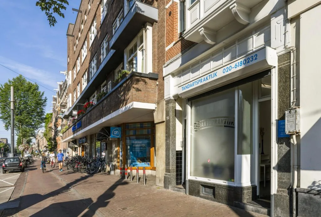 Vooraanzicht van een tandartspraktijk en Albert Heijn op de Overtoom in Amsterdam.