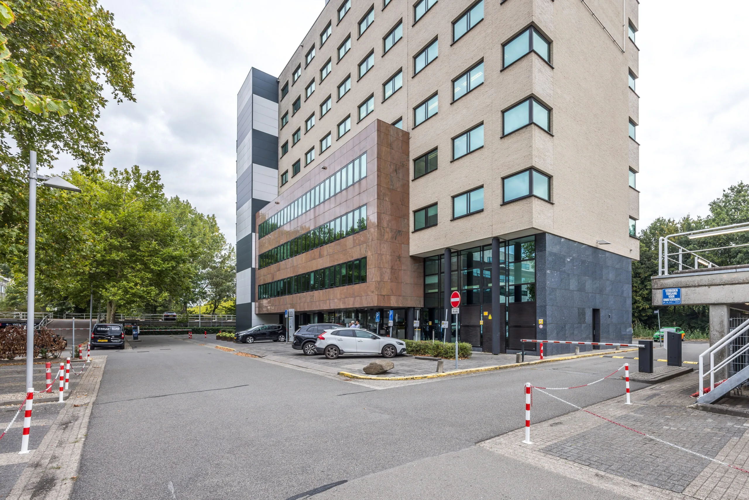 Kantoorgebouw aan de Daltonlaan met parkeergelegenheid en toegangsweg met slagboom.