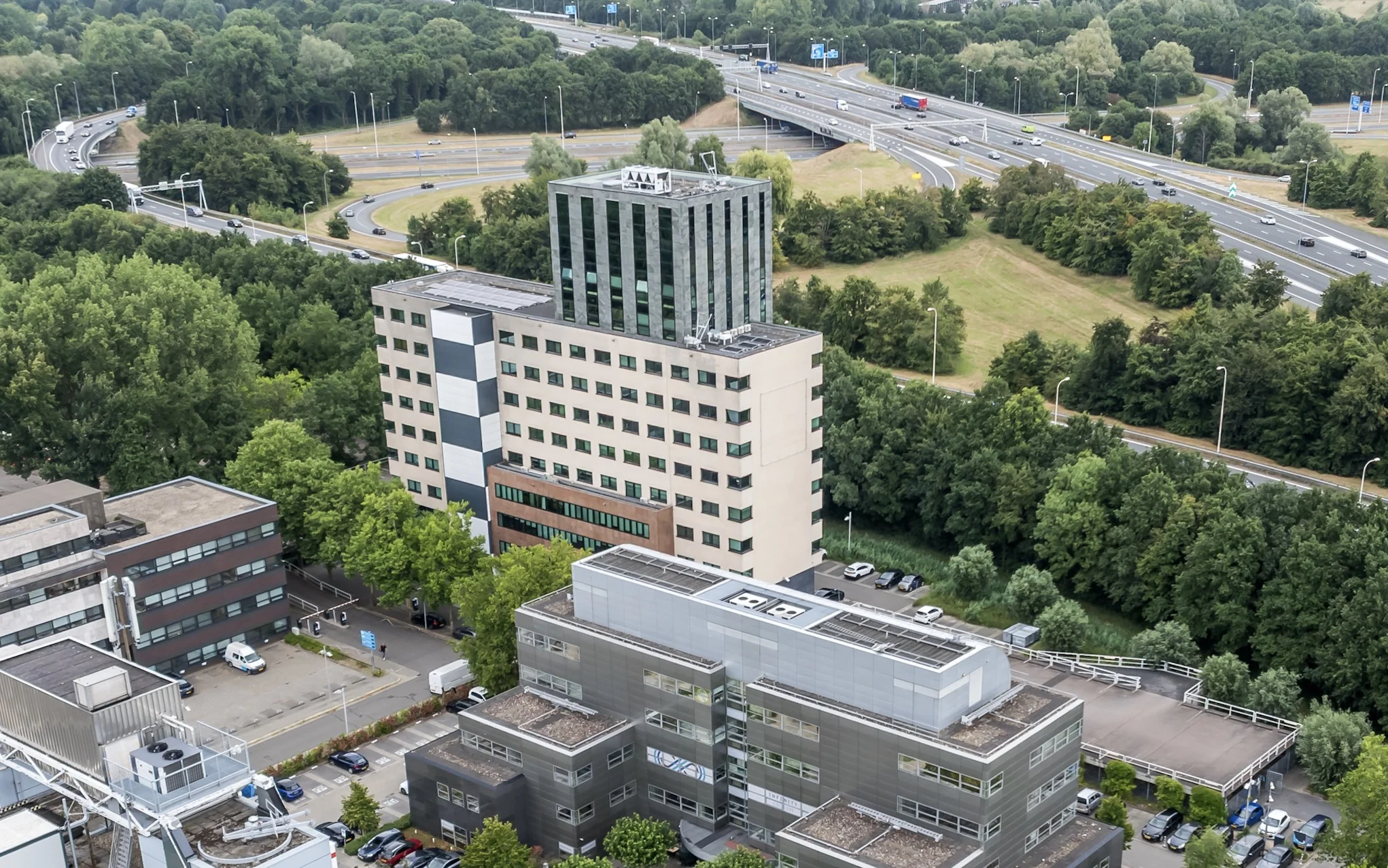 Luchtfoto van een kantoorgebouw aan de Daltonlaan in Utrecht, omringd door groen en nabij snelwegen.