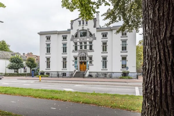 Wit historisch pand aan de Driebergseweg met de naam 'Kosmos' op de gevel, gezien vanaf de overkant van de straat.