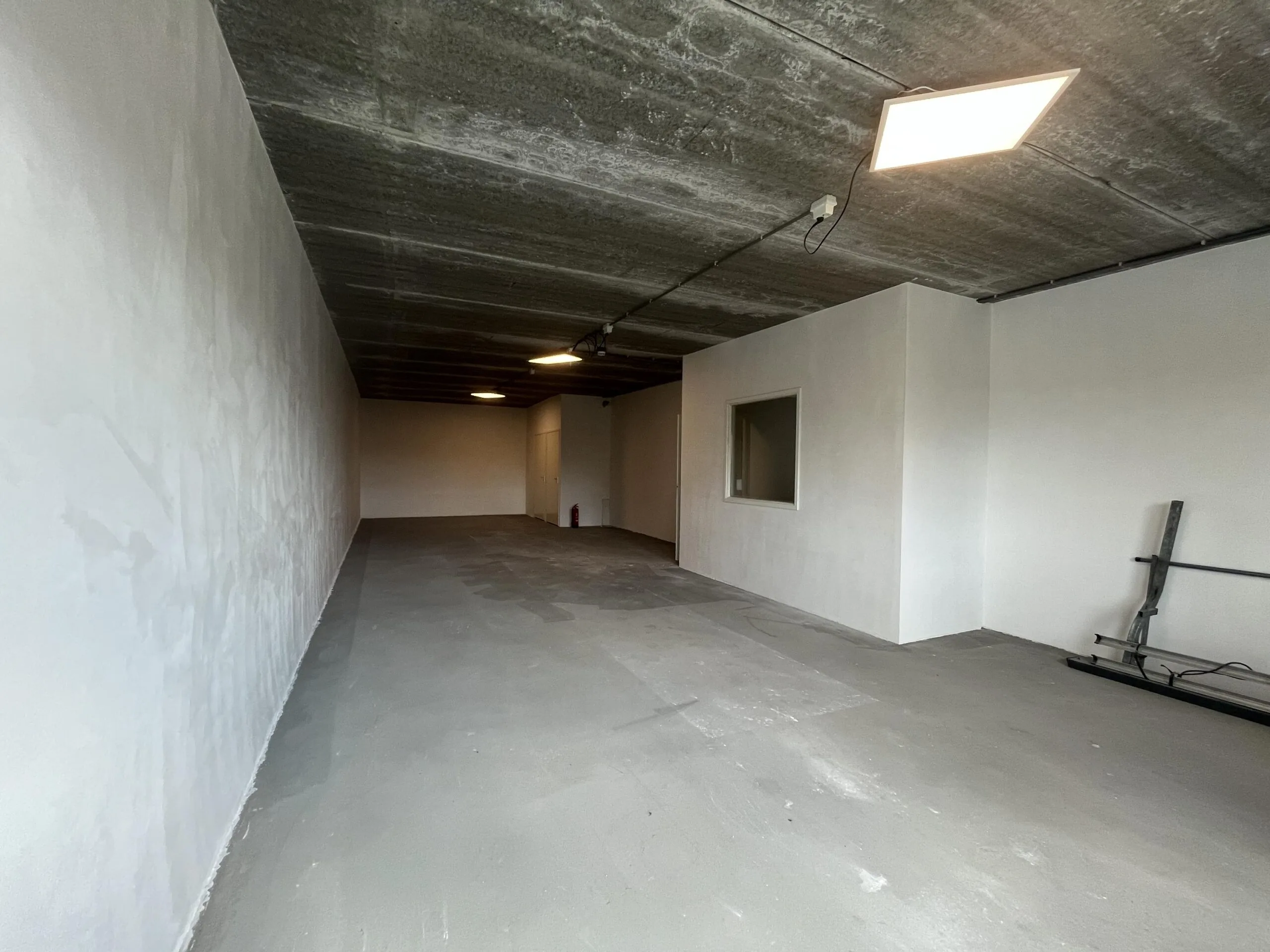 Leeg bedrijfsruimte-interieur aan de Broekdijk West met betonnen vloer en plafond.
