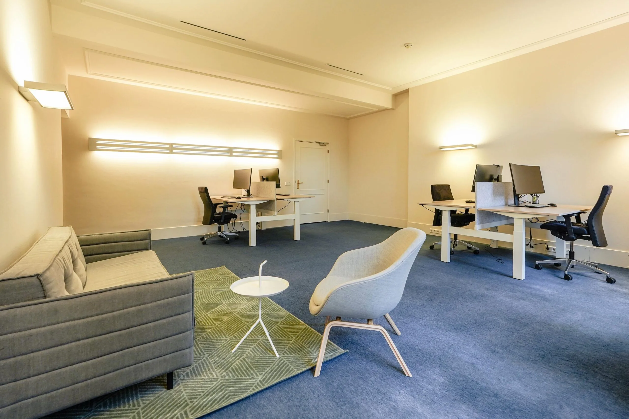Modern kantoorinterieur aan de Utrechtseweg met vier werkplekken, een zithoek en zachte verlichting.