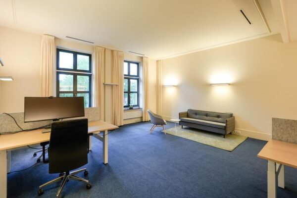 Modern ingericht kantoor aan de Utrechtseweg met werkplekken, zithoek en grote ramen.