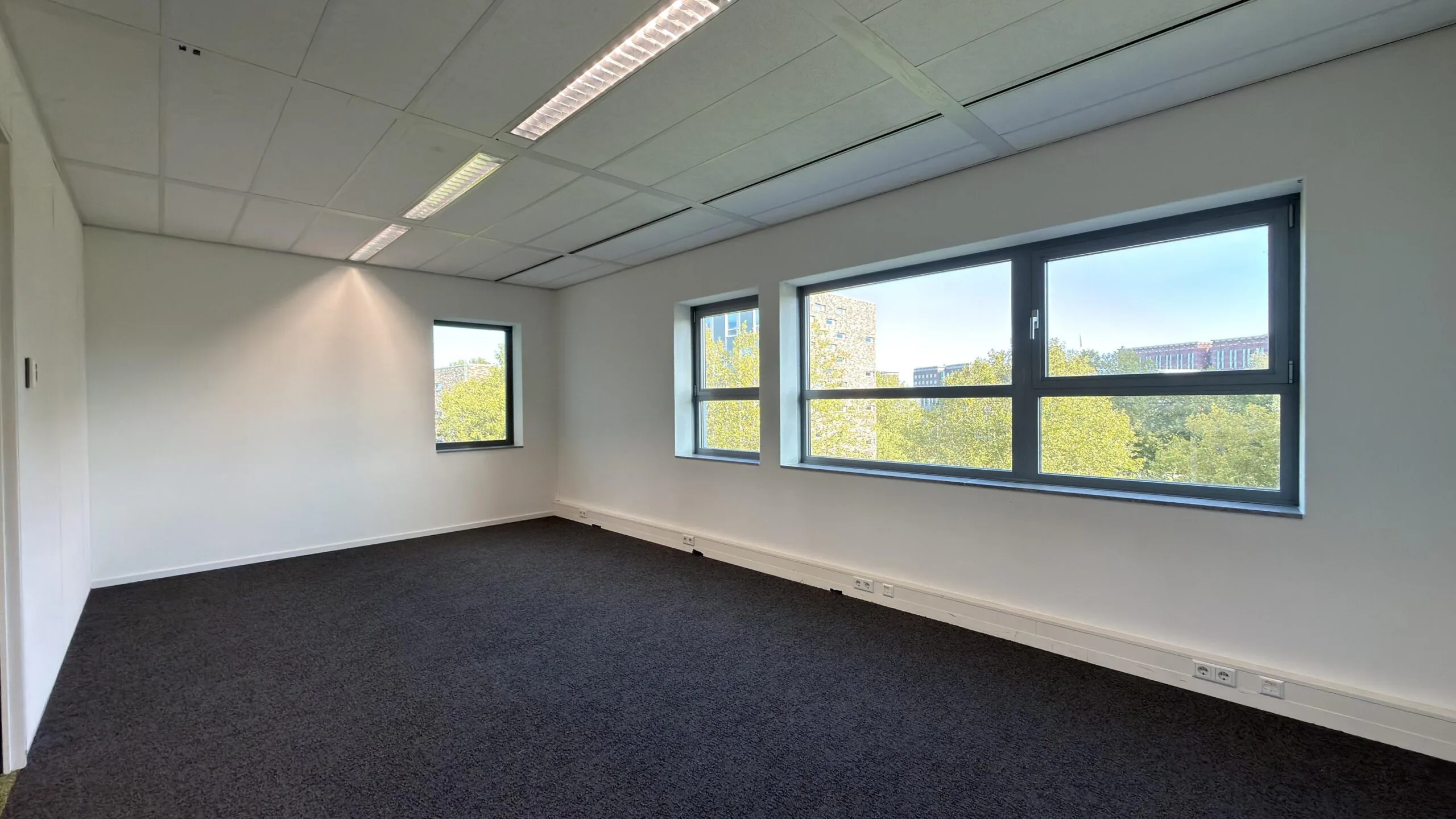 Licht en leeg kantoor met grote ramen en uitzicht op groen, gelegen aan de Papendorpseweg.