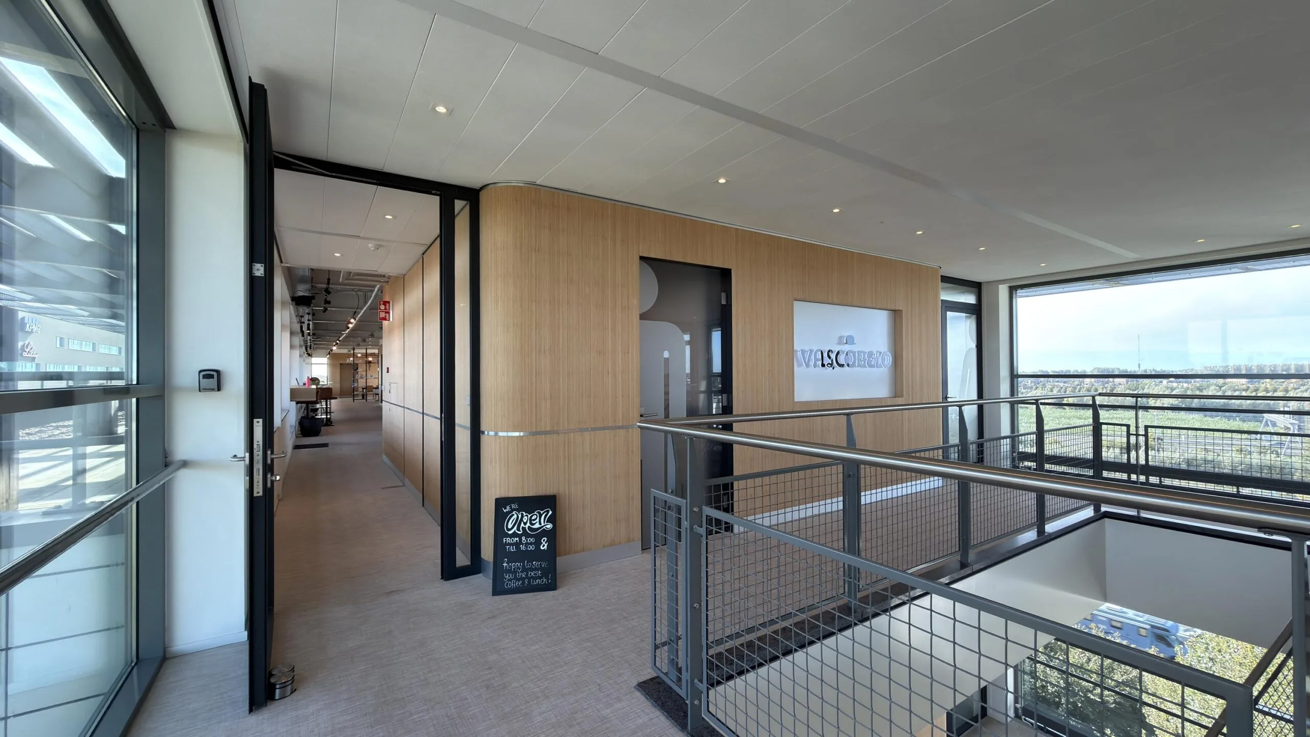 Moderne kantoorruimte aan de Papendorpseweg met houten wandbekleding, glazen deuren en uitzicht op groen landschap.