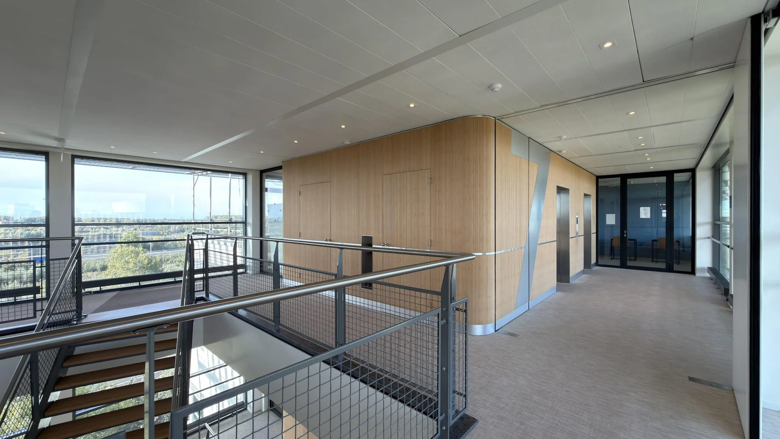 Moderne kantoorverdieping aan de Papendorpseweg met houten afwerking, grote ramen en een stalen trap.