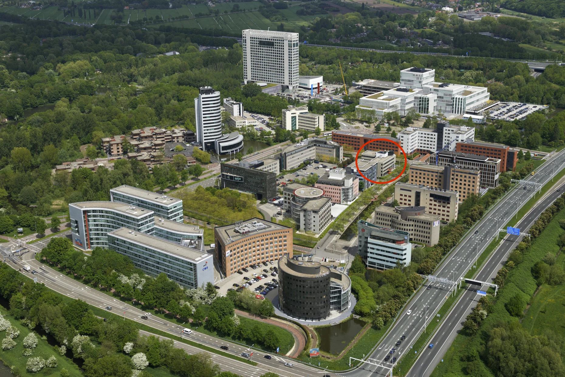 Luchtfoto van kantorenpark op de Varrolaan in Utrecht, met een gebouw in het midden gemarkeerd met een rode cirkel.