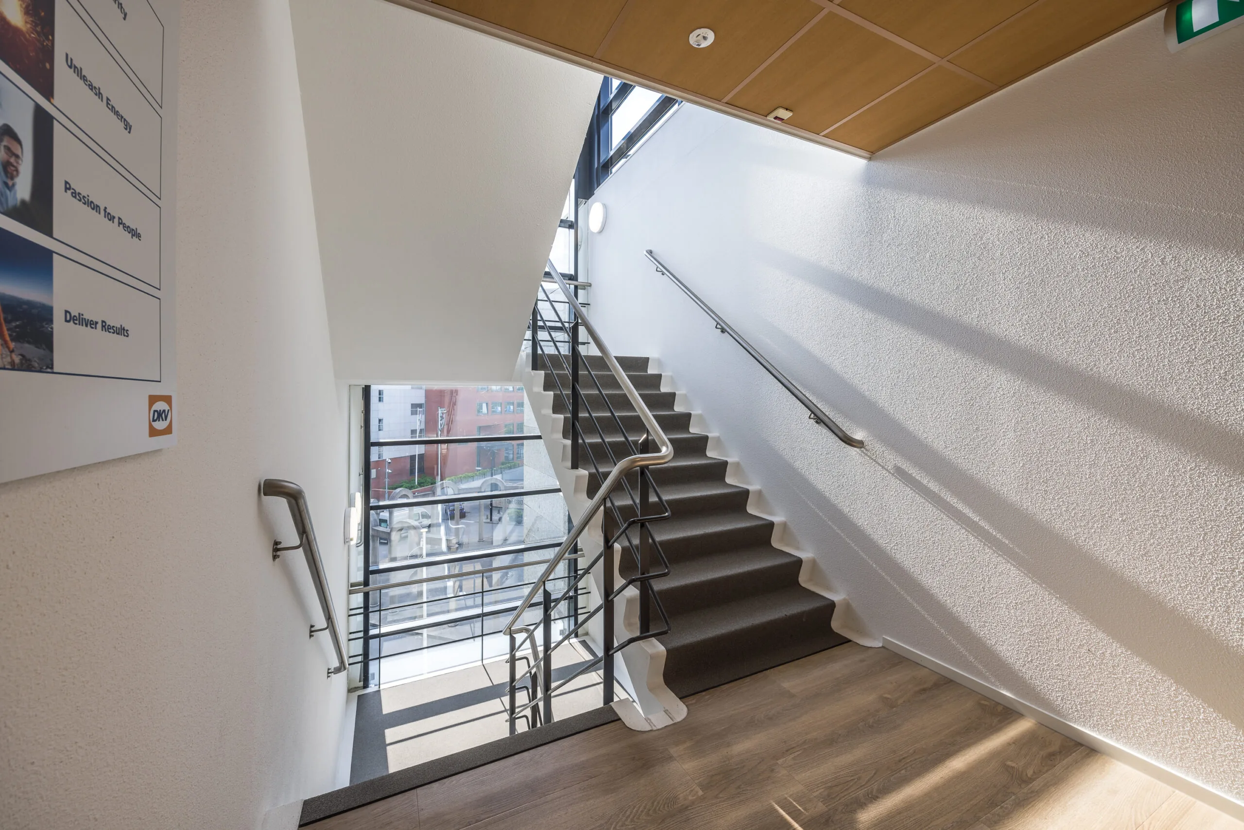 Trapportaal met veel daglicht en uitzicht op gebouwen aan de Varrolaan.