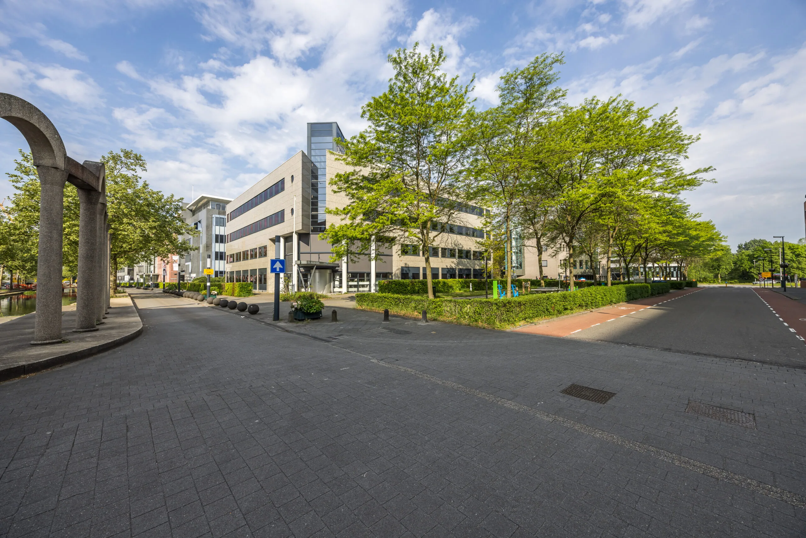 Kantoorgebouwen aan de Varrolaan in een groene, stedelijke omgeving met brede straten en fietspaden.