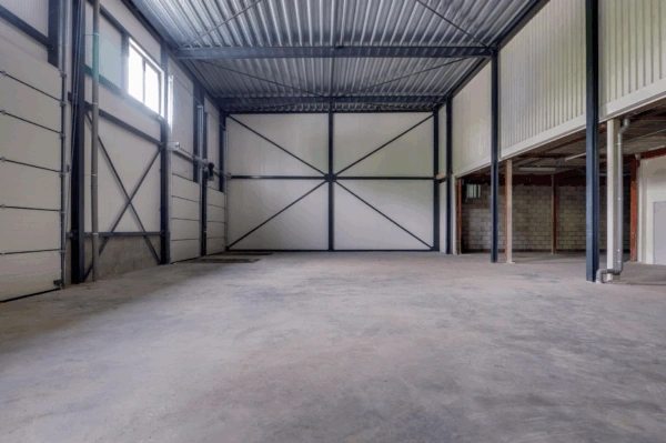 Interieur van een lege bedrijfsruimte aan de Australielaan met hoge plafonds en industriële afwerking.