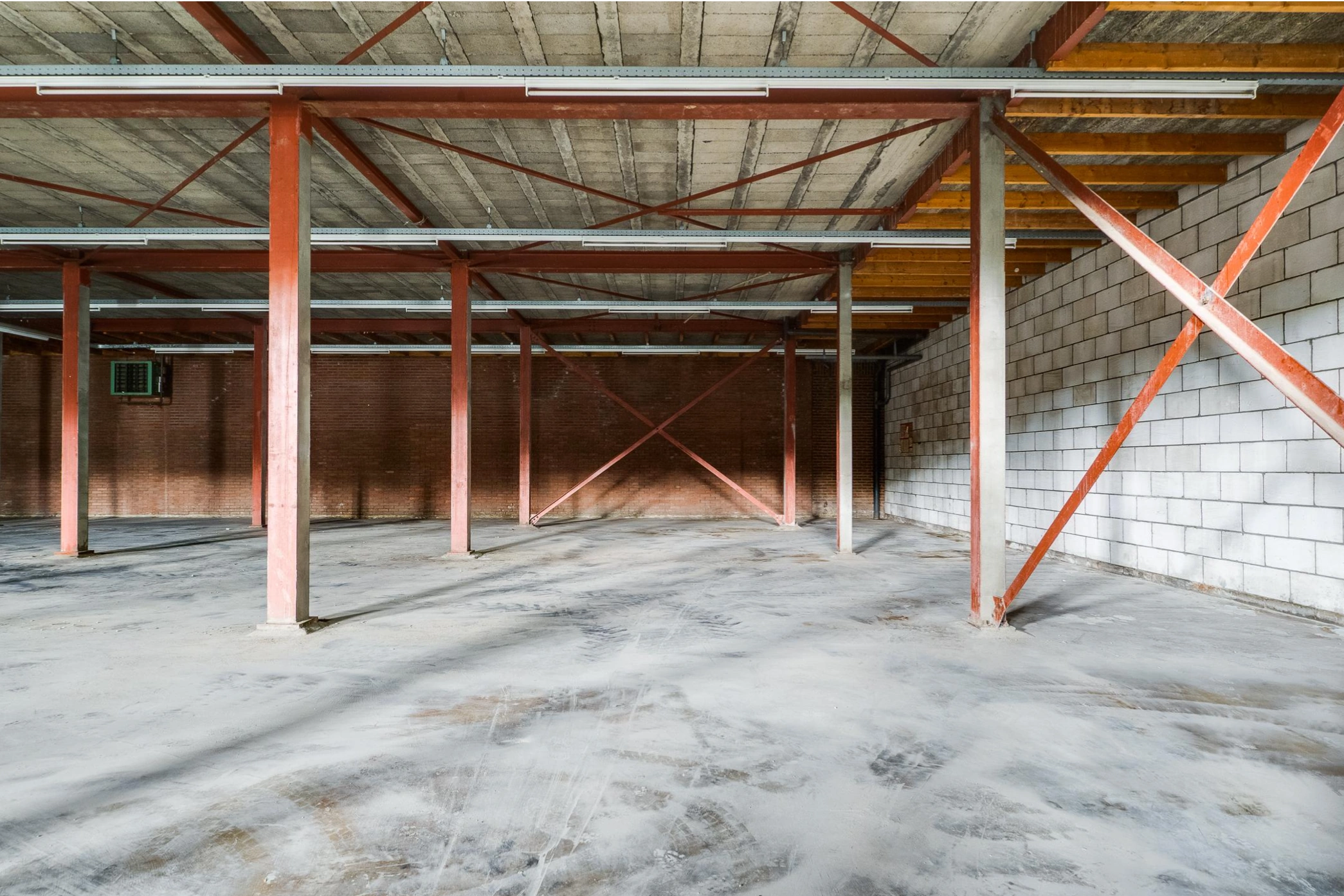 Lege industriële loods aan de Australiëlaan met zicht op betonnen vloer, stalen draagconstructie en onafgewerkte binnenmuren.