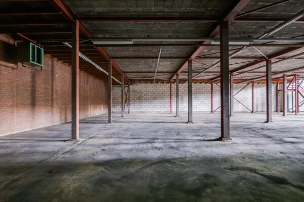 Lege bedrijfsruimte met betonnen vloer, zichtbare stalen constructie en bakstenen muren aan de Australielaan.