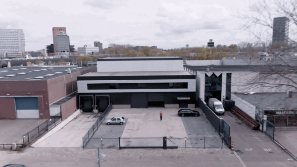 Luchtfoto van een bedrijfsgebouw aan de Australiëlaan met parkeerterrein en twee geparkeerde auto's.