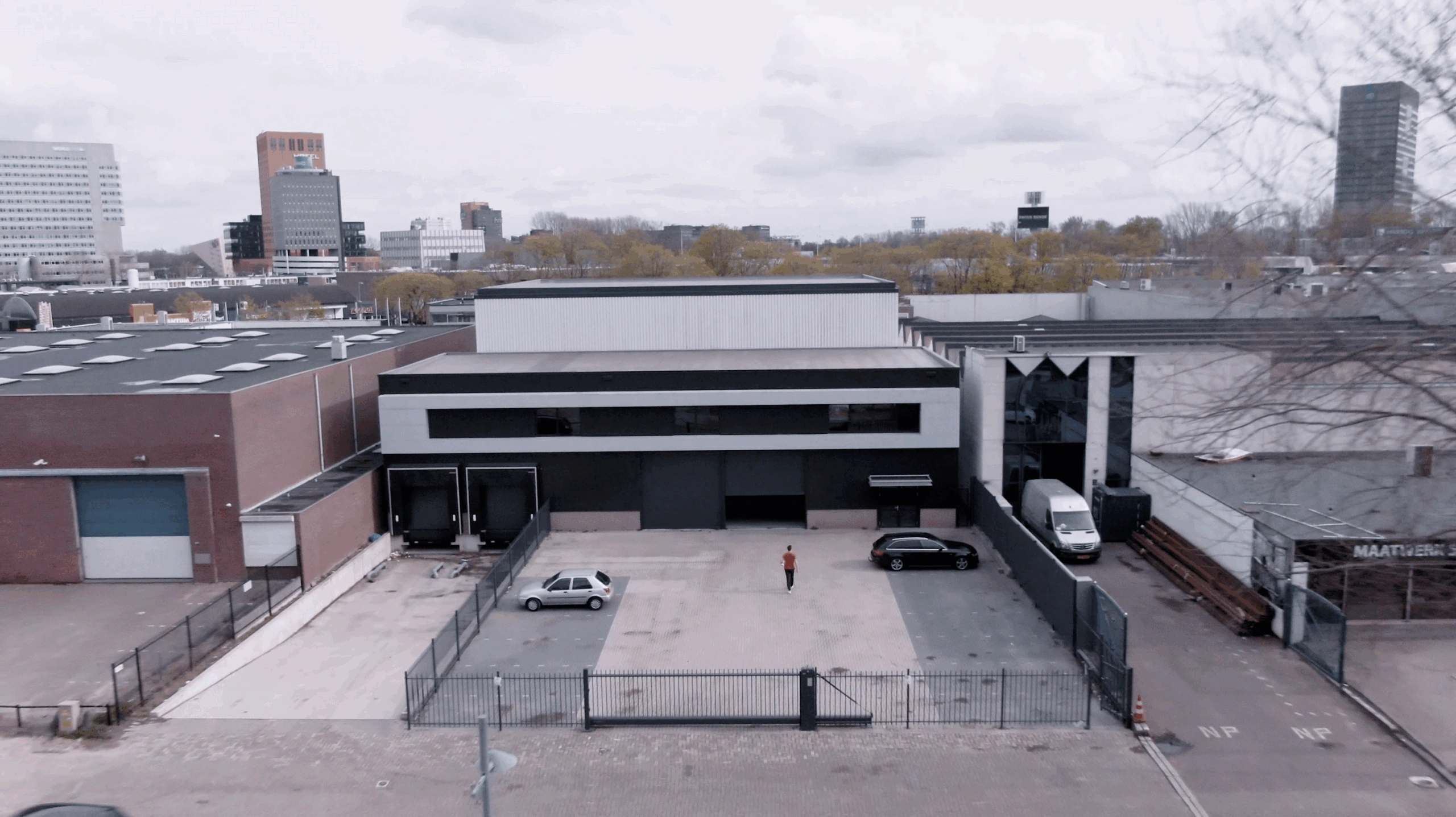 Luchtfoto van een bedrijfsgebouw aan de Australiëlaan met parkeerterrein en twee geparkeerde auto's.