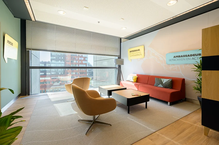 Moderne wachtruimte aan de Wilhelminakade met grote ramen, comfortabele zitmeubels en inspirerende muurteksten.