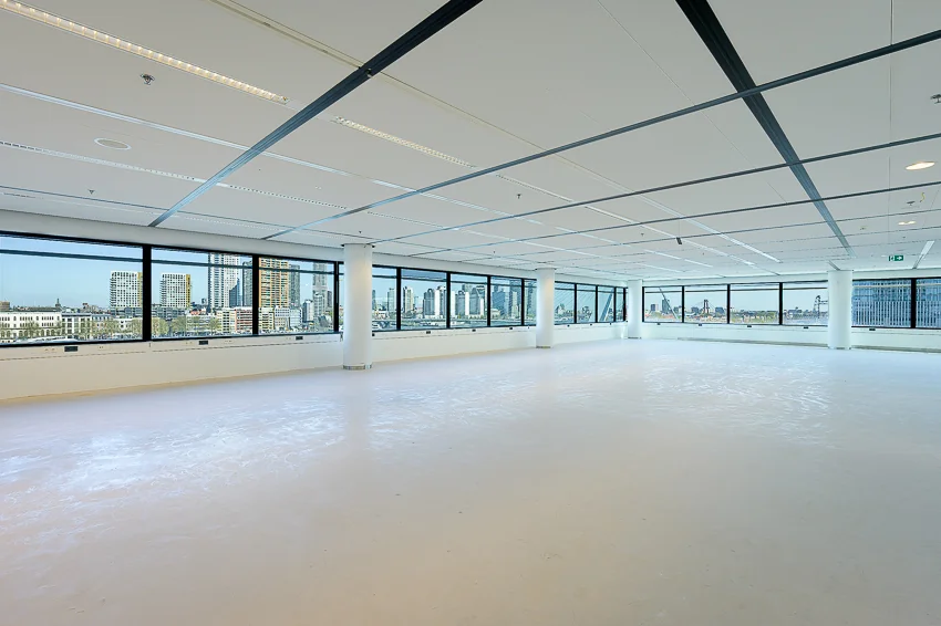 Lichte, lege kantoorruimte aan de Wilhelminakade met panoramisch uitzicht op de skyline van Rotterdam.