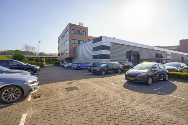 Parkeerterrein met geparkeerde auto's voor het Regenboog Business Center aan de Laan van 's-Gravenmade.