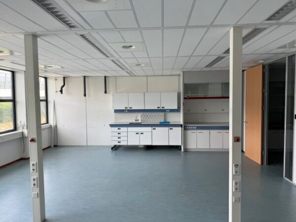 Leeg laboratorium met werkbanken en opbergkasten aan de Laan van s-Gravenmade.