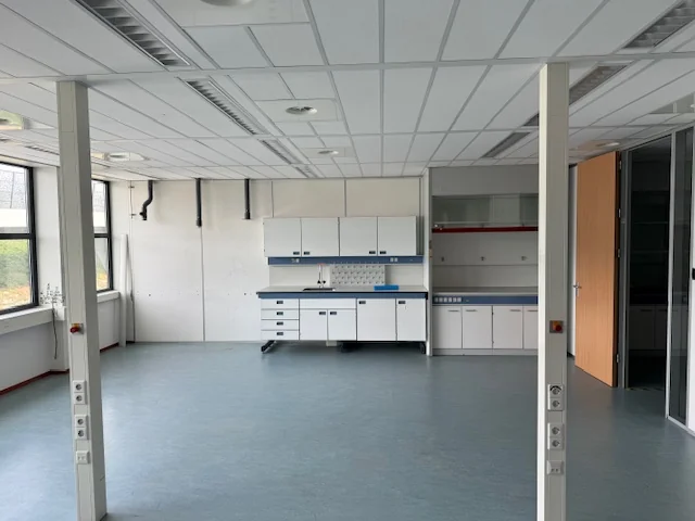 Leeg laboratorium met werkbanken en opbergkasten aan de Laan van s-Gravenmade.