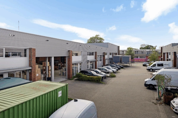 Bedrijventerrein aan de Schaafstraat met geparkeerde auto’s, bestelwagens en openstaande bedrijfspanden.