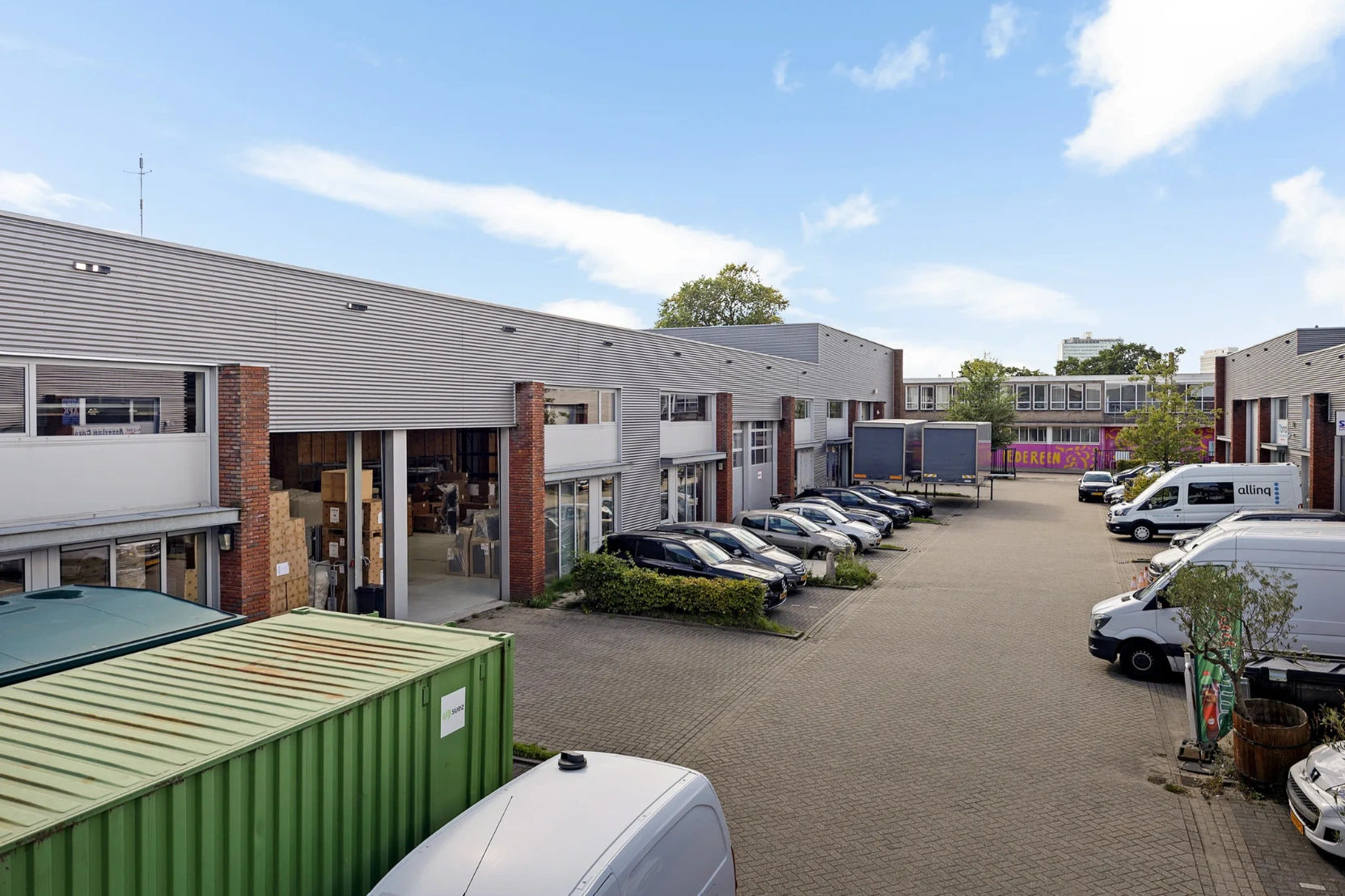 Bedrijventerrein aan de Schaafstraat met geparkeerde auto’s, bestelwagens en openstaande bedrijfspanden.