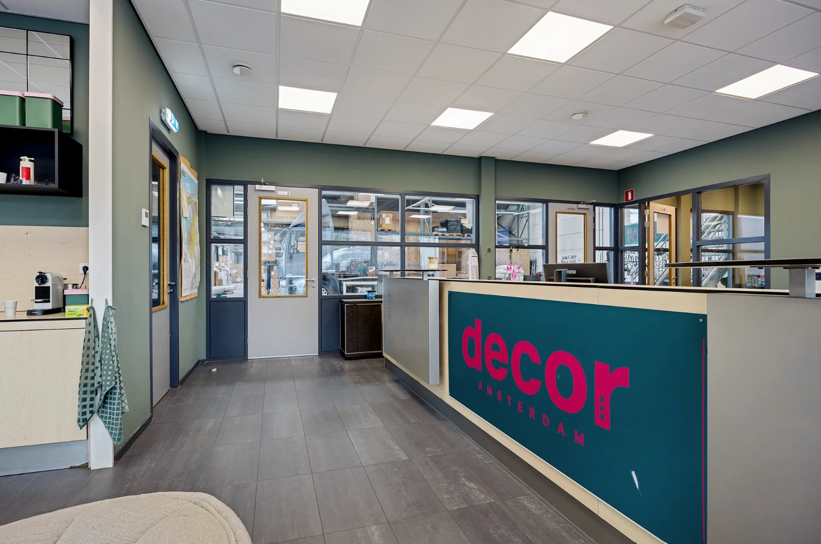 Moderne receptie met balie van Decor Amsterdam in een lichte, industrieel ingerichte kantoorruimte aan de Schaafstraat.