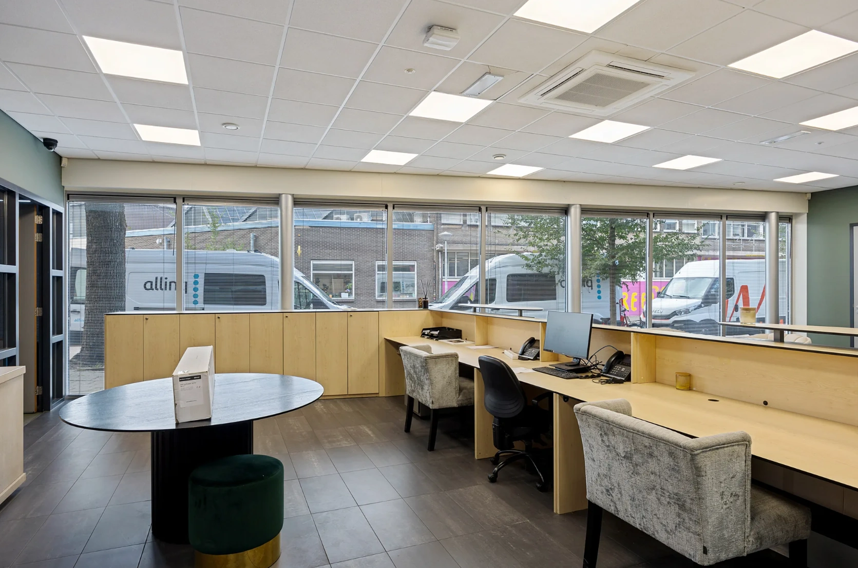 Moderne kantoorruimte aan de Schaafstraat met werkplekken, grote ramen en uitzicht op geparkeerde bestelwagens.