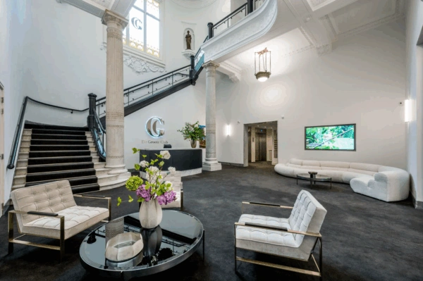Moderne en stijlvolle lobby van De Groote Club aan de Paleisstraat, met klassieke elementen en eigentijdse inrichting.