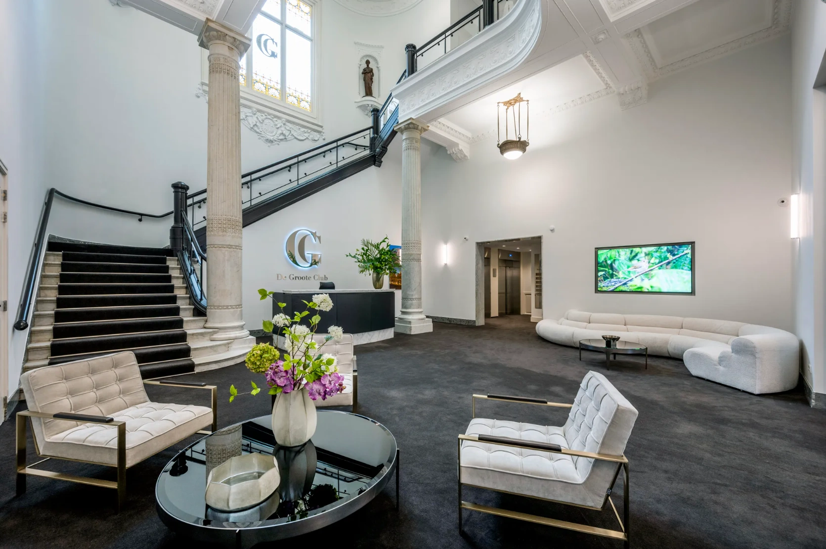Moderne en stijlvolle lobby van De Groote Club aan de Paleisstraat, met klassieke elementen en eigentijdse inrichting.