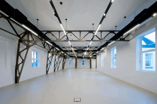 Moderne, open ruimte aan de Paleisstraat met industriële stalen spanten en strakke verlichting.