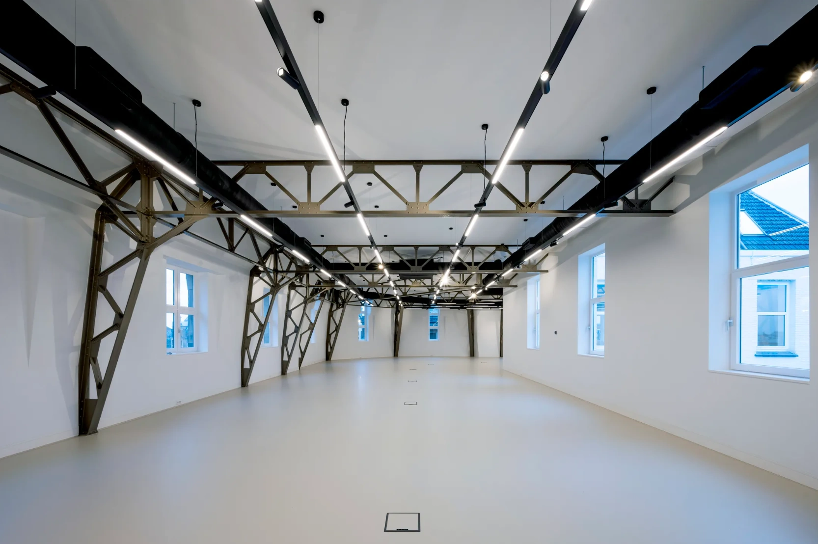 Moderne, open ruimte aan de Paleisstraat met industriële stalen spanten en strakke verlichting.