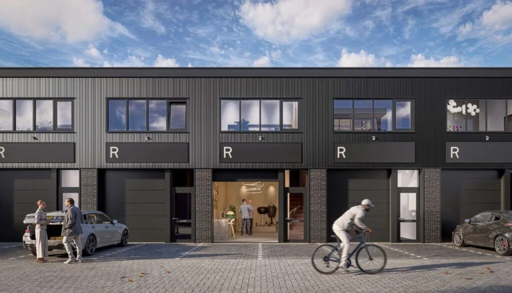 Moderne bedrijfsunits aan de Hoofdweg met grote ramen, zwarte gevelbekleding en mensen op de voorgrond.