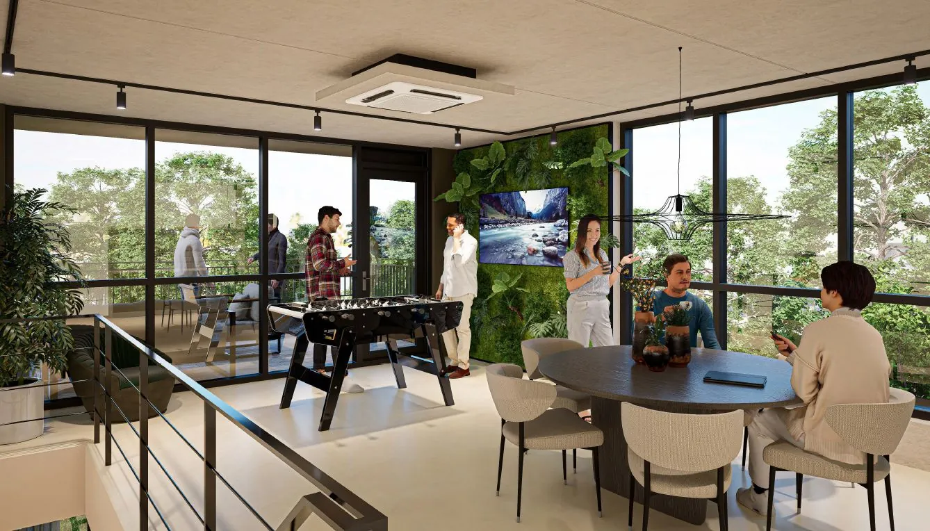Moderne gemeenschappelijke ruimte in The Hub aan de Hoofdweg met mensen die ontspannen, tafelvoetbal spelen en praten in een groen ingerichte omgeving.