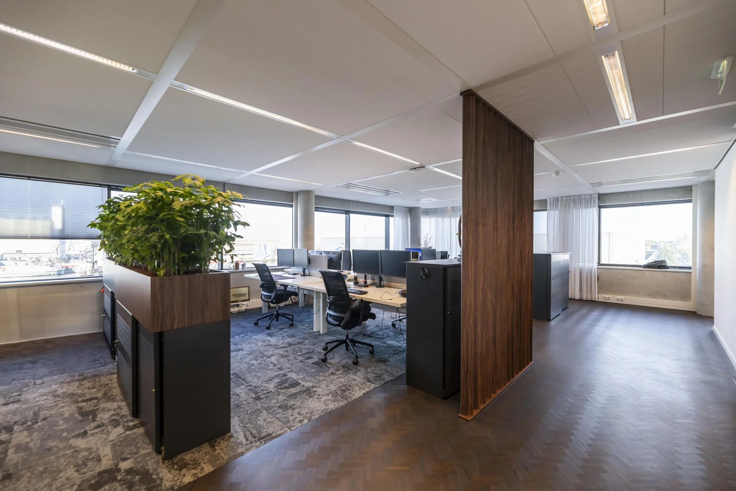 Modern kantoorinterieur aan de Havenstraat met werkplekken, bureaustoelen en grote ramen.