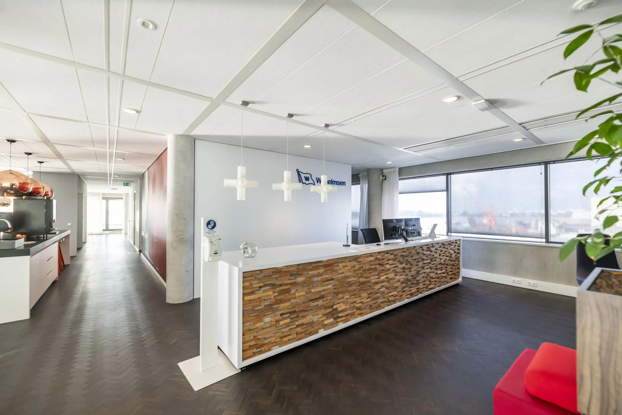 Moderne receptiebalie van Wilhelmsen aan de Havenstraat met houten afwerking en uitzicht op de haven.
