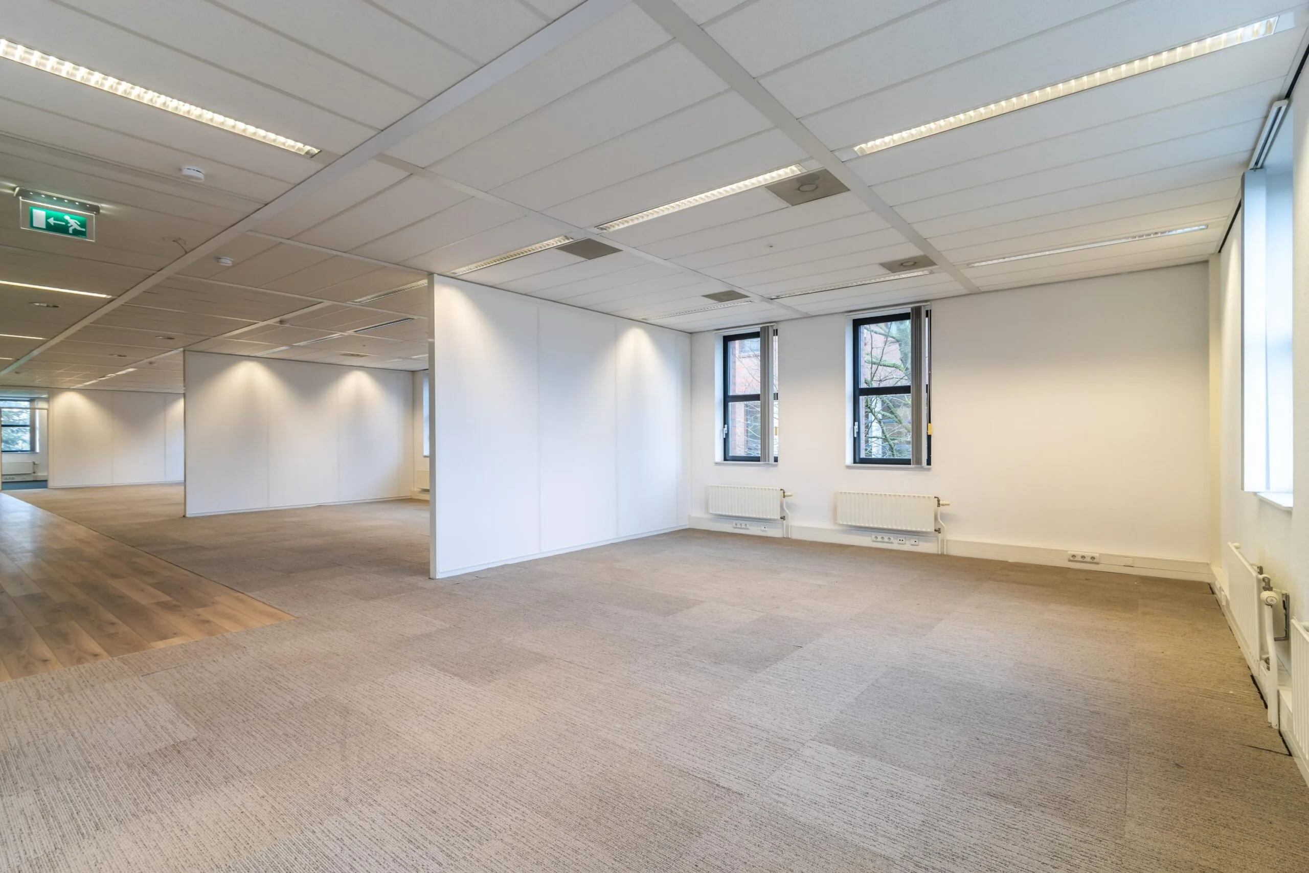 Licht en ruim kantoorpand aan de Lange Dreef met systeemplafond, tapijtvloer en meerdere ramen.