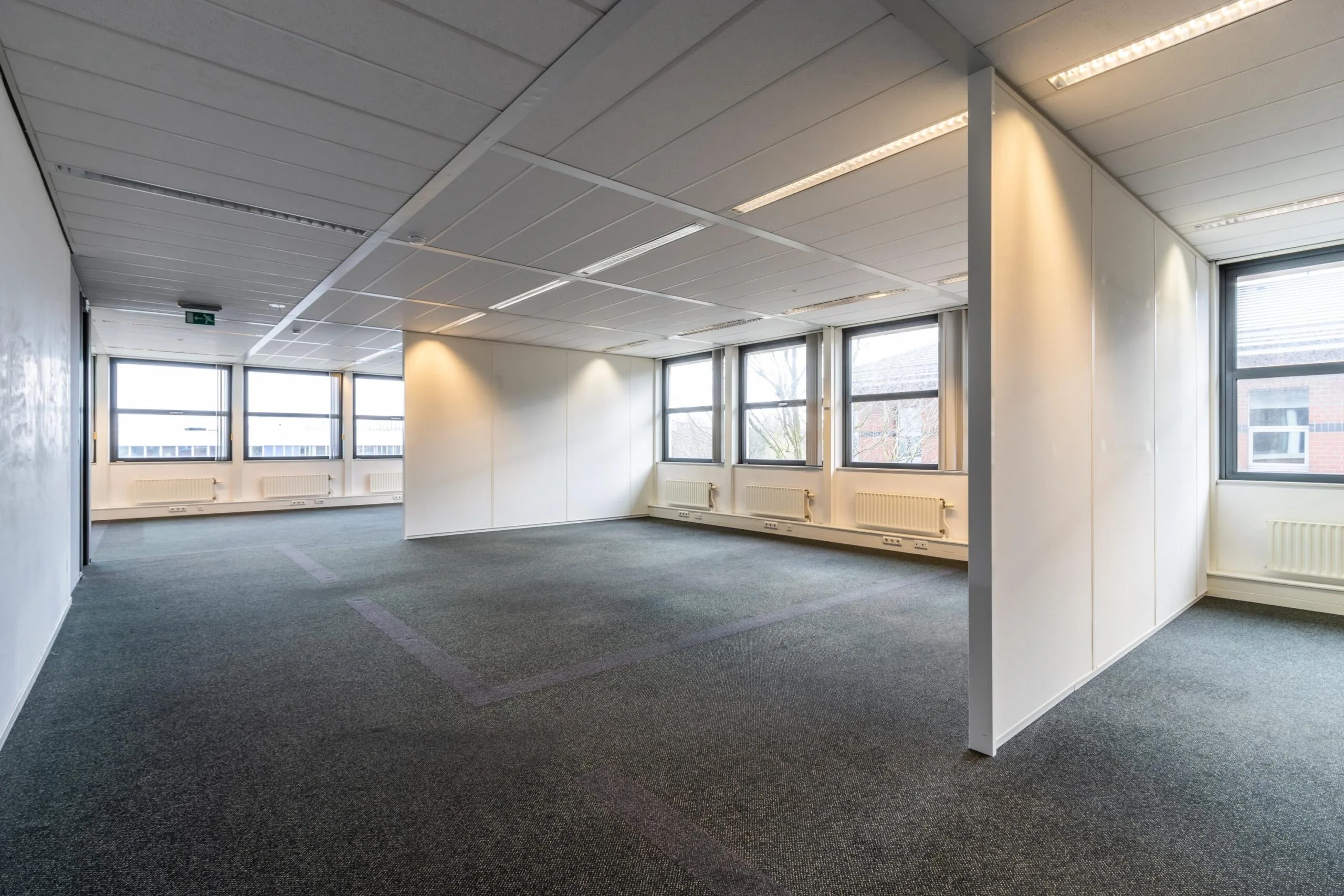 Licht en ruim leeg kantoorinterieur aan de Lange Dreef met grote ramen en systeemplafond.
