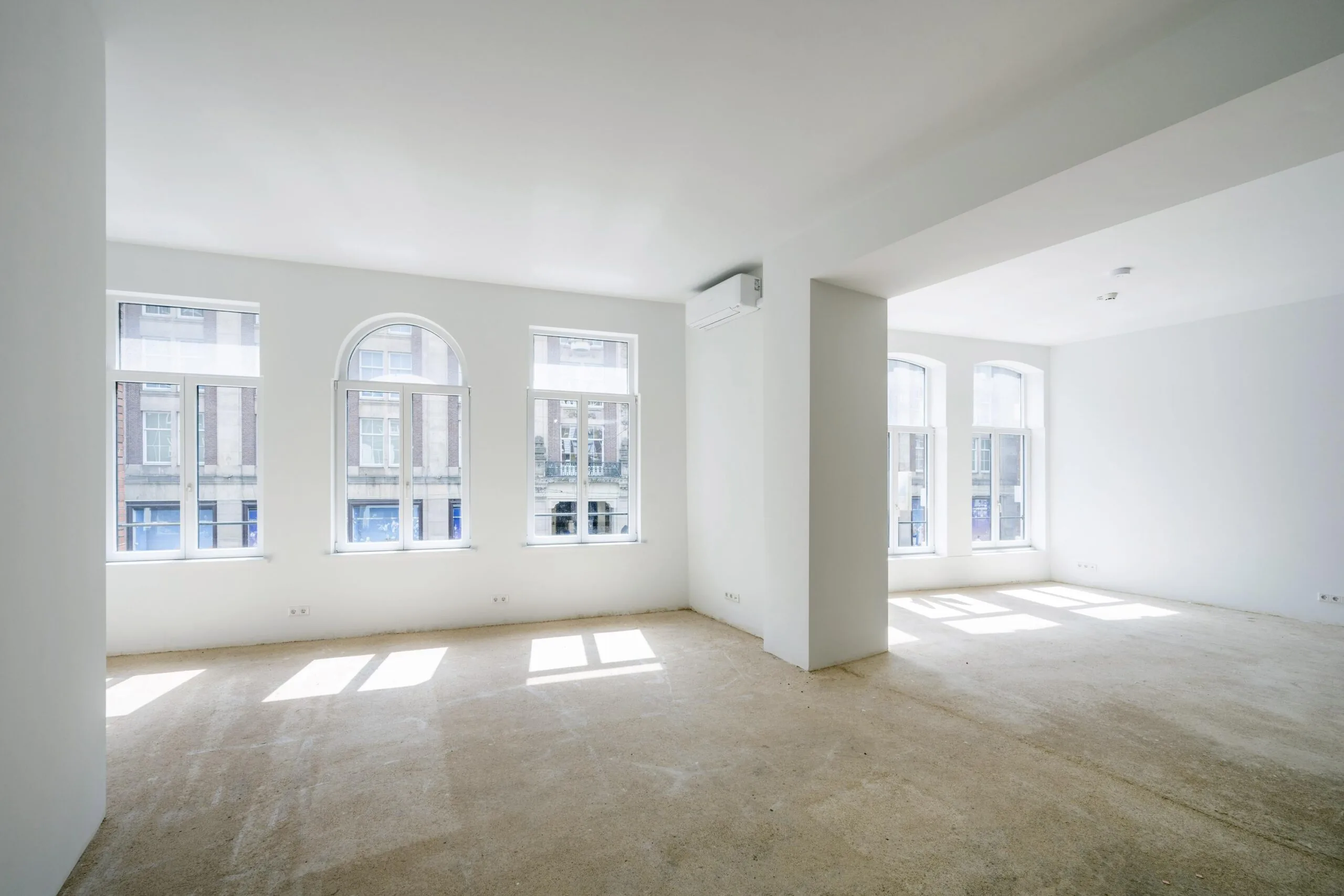 Lichte, lege ruimte met grote ramen aan het Damrak in Amsterdam.