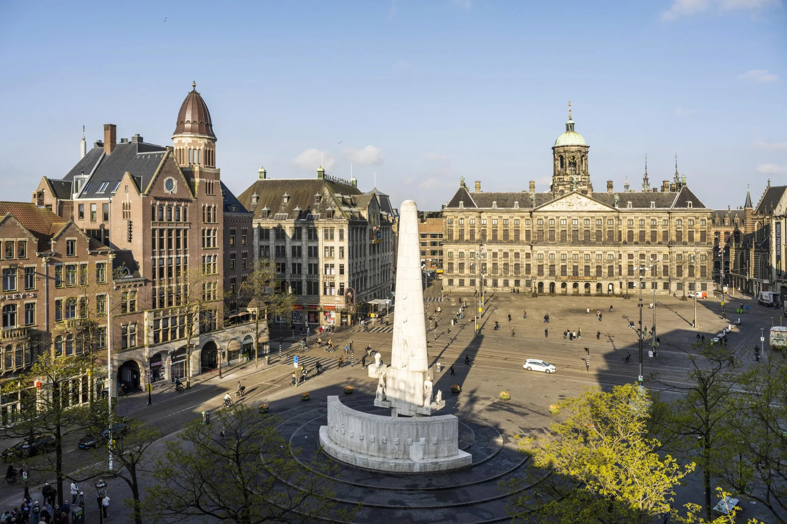 Het Nationaal Monument op de Dam met het Koninklijk Paleis Amsterdam op de achtergrond bij helder weer.