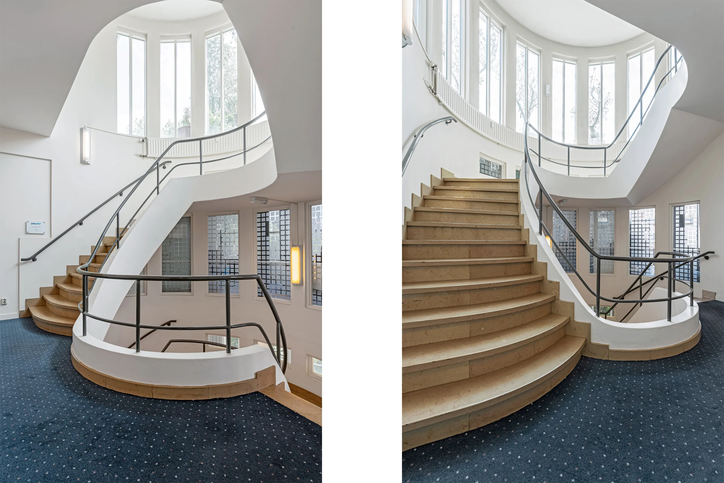 Curved staircase with wooden steps and metal railings in a bright, modern interior with large vertical windows at Rozenlaan.