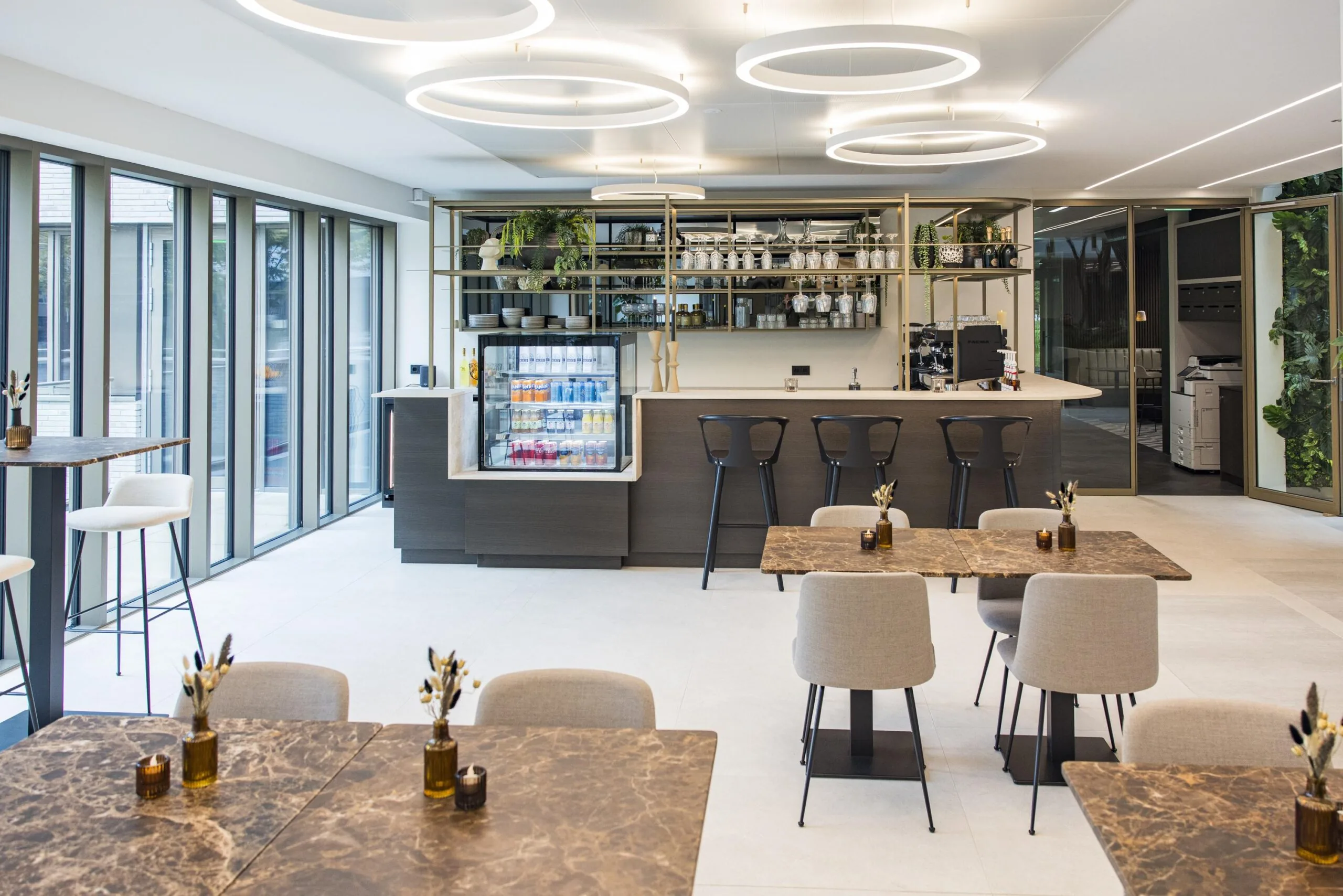 Modern café interior with marble-top tables, a sleek bar, and circular ceiling lights at Walborg.