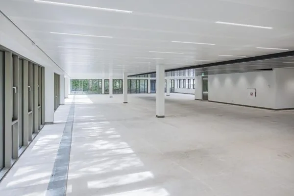 Spacious empty office floor in the Walborg building with large windows and white interior.