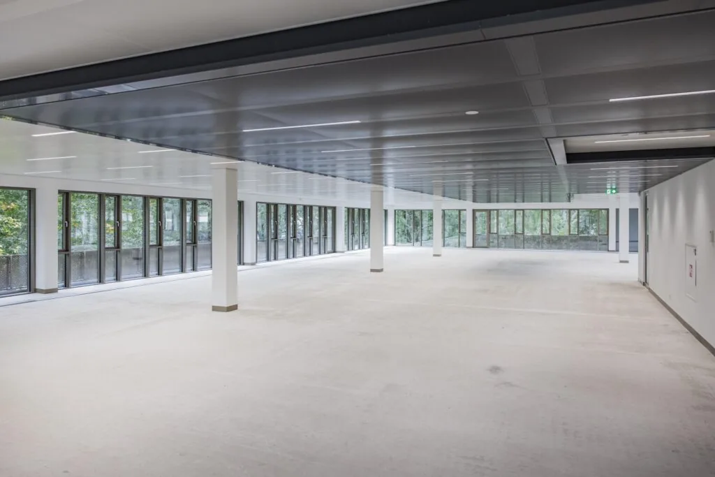 Spacious empty office floor with large windows and modern ceiling at Walborg 176.