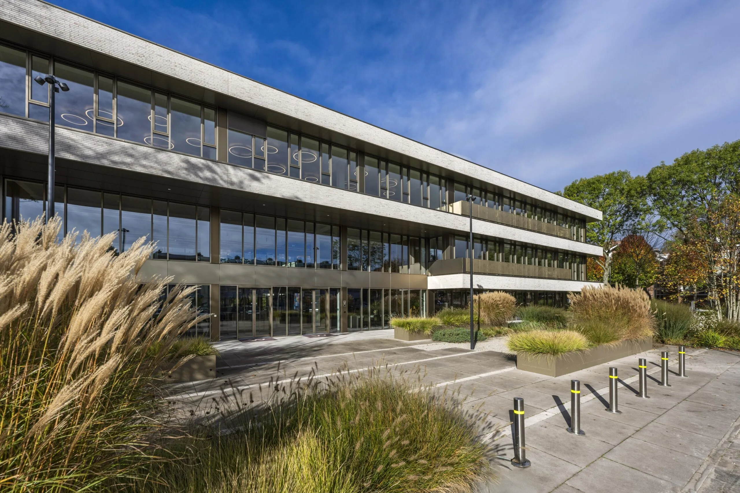 Modern office building "Walborg" with large glass windows and landscaped greenery at the entrance.