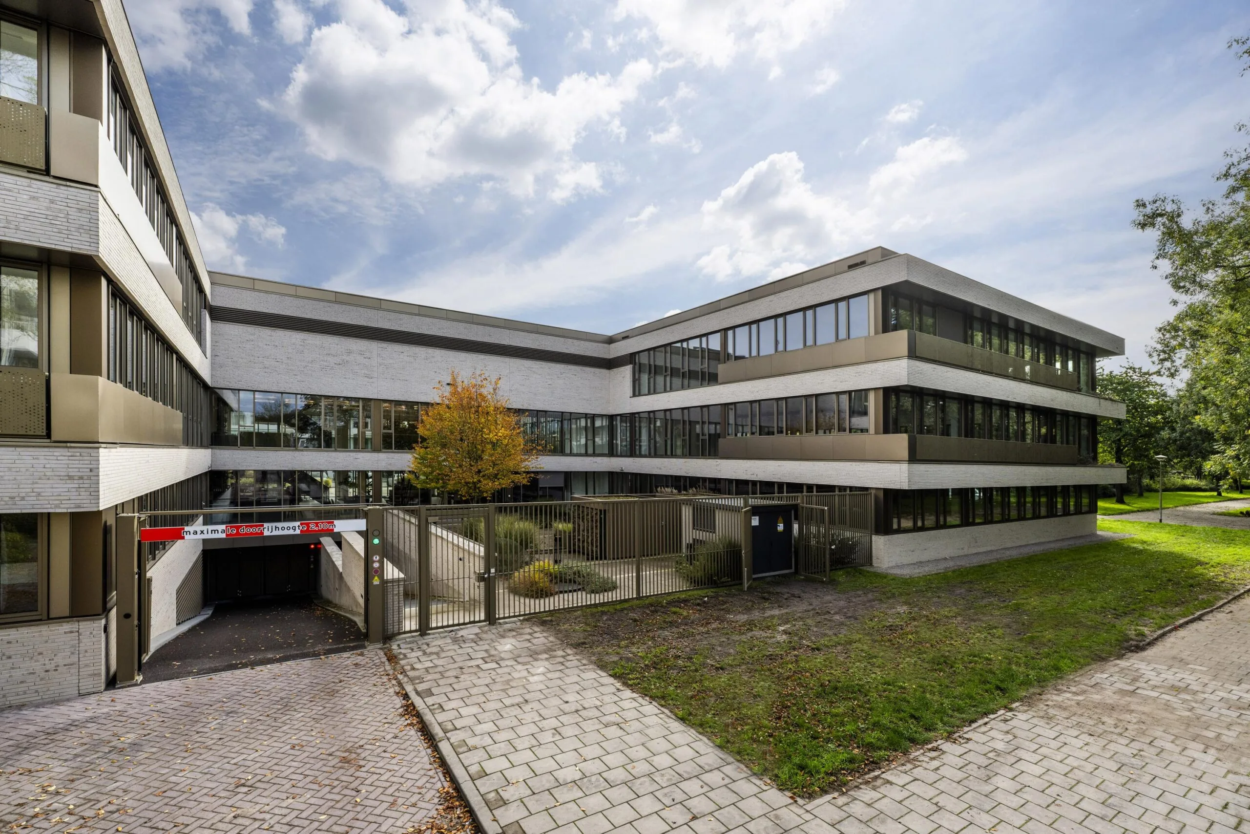 Modern office building 'Walborg' with large windows and an underground parking entrance.