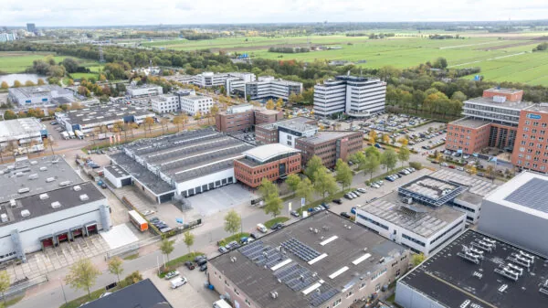 Aerial view of the Veldzigt business park featuring office buildings, warehouses, and surrounding green fields.
