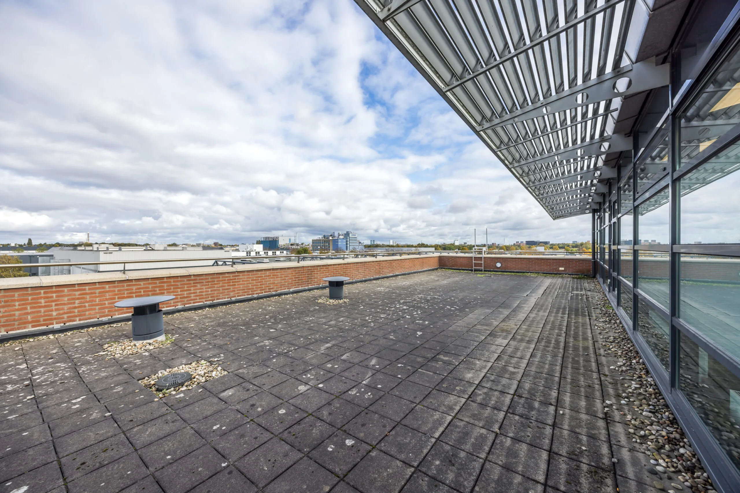 Spacious rooftop terrace of the Veldzigt building with a view over surrounding industrial and office areas.