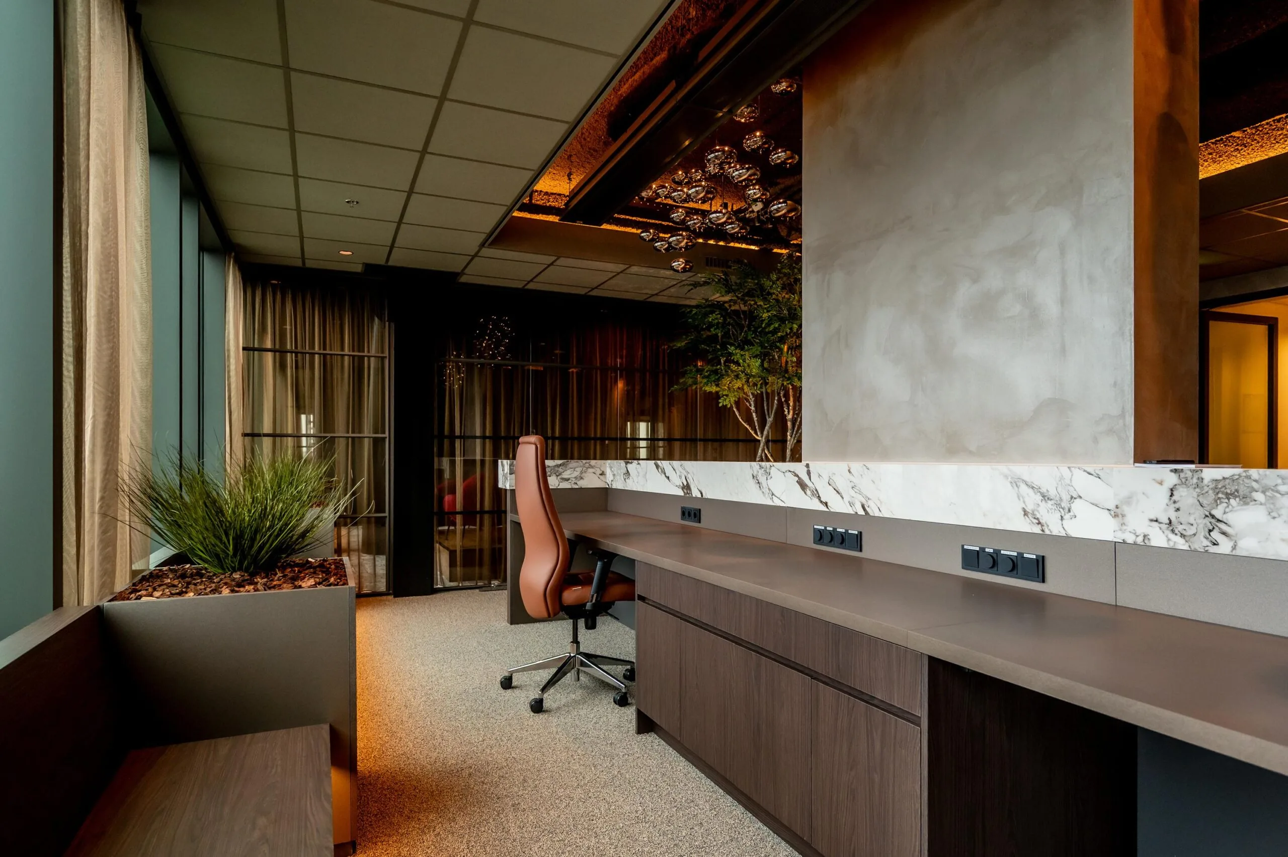 Modern office interior on P.J. Oudweg featuring a sleek marble-accented desk, ergonomic chair, and warm ambient lighting.